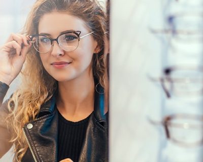 Junge Frau testet eine neue Brille beim Optiker